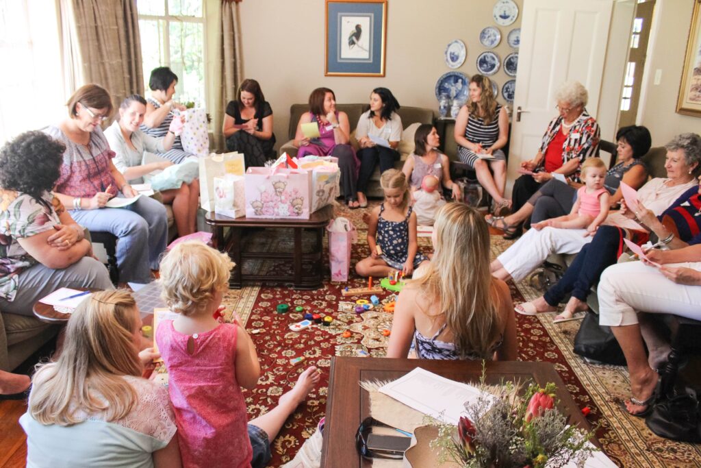 Baby shower guests writing down Baby Shower Memory Game items they remember 