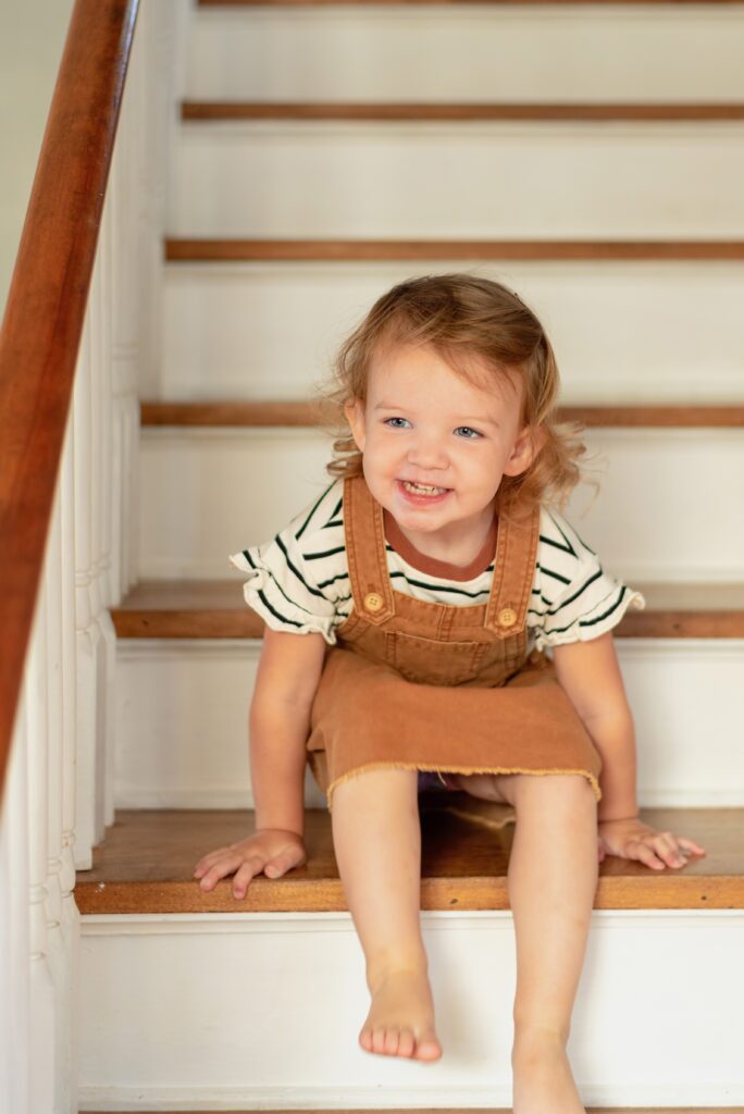 Candid gorgeous picture of a toddler on the stairs laughing 