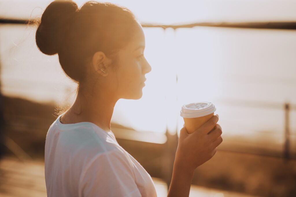 young-woman-drinking-coffee-at-sunset - Don't Fall Prey To Desperation