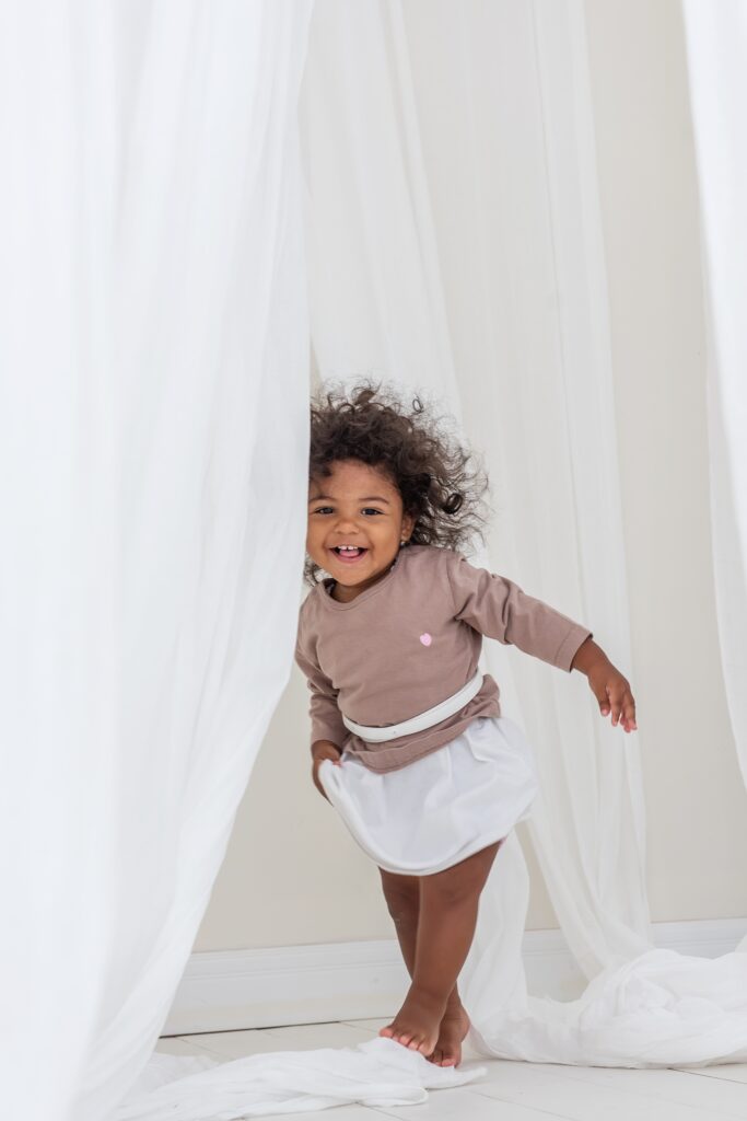 happy-little-african-american-girl-laughs-the-baby-stands-in-white-developing-tissues-happiness_t20_kL8vv4