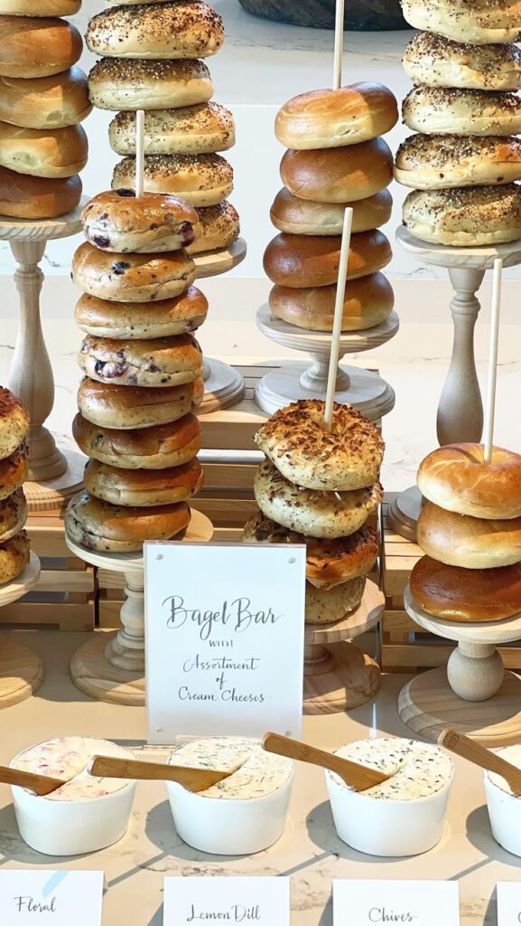A bagel bar with different flavors of bagels and an assortment of cream cheese spreads for a baby shower brunch.